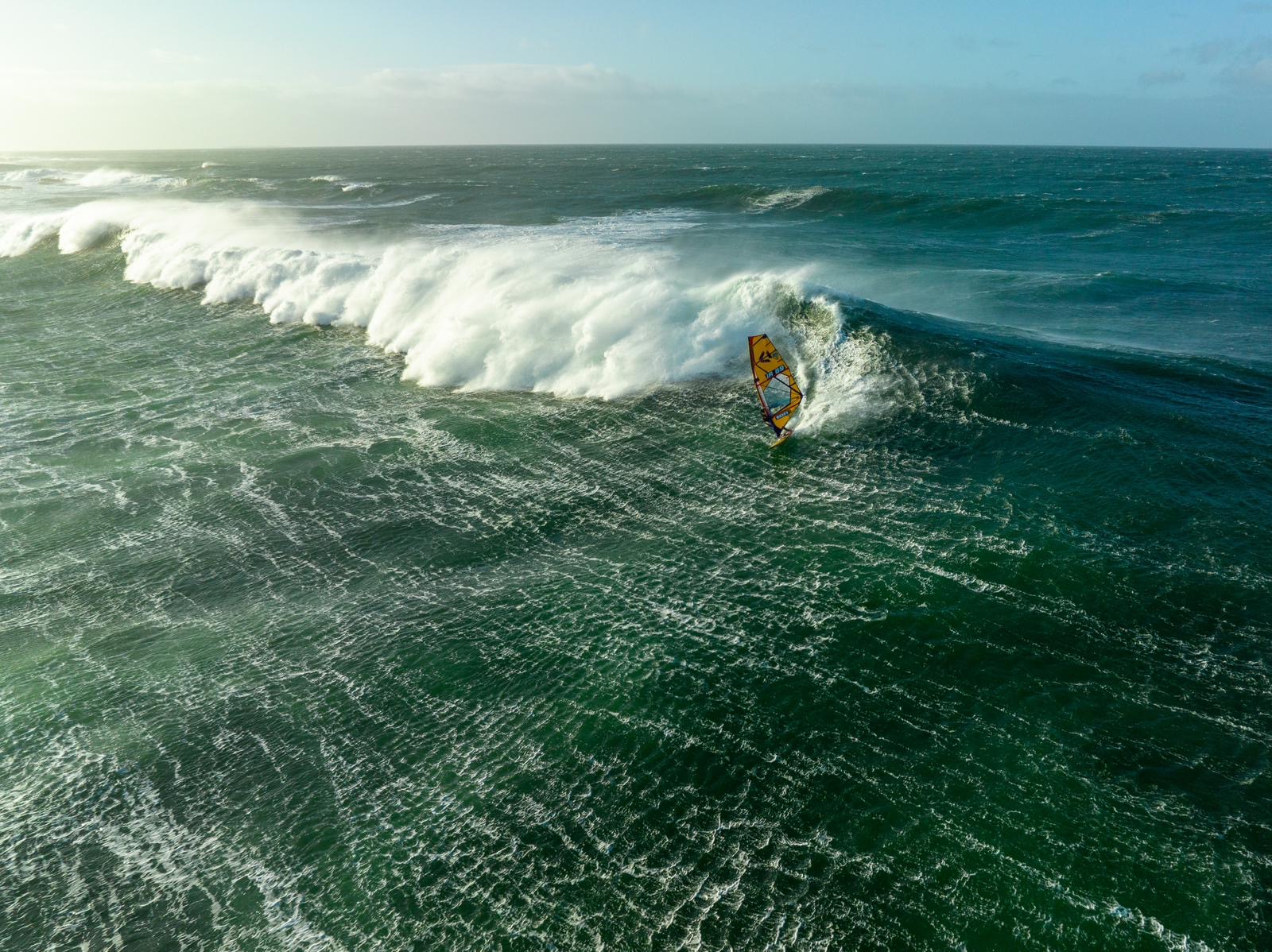 Drone shot of a windsurfer riding a large wave
