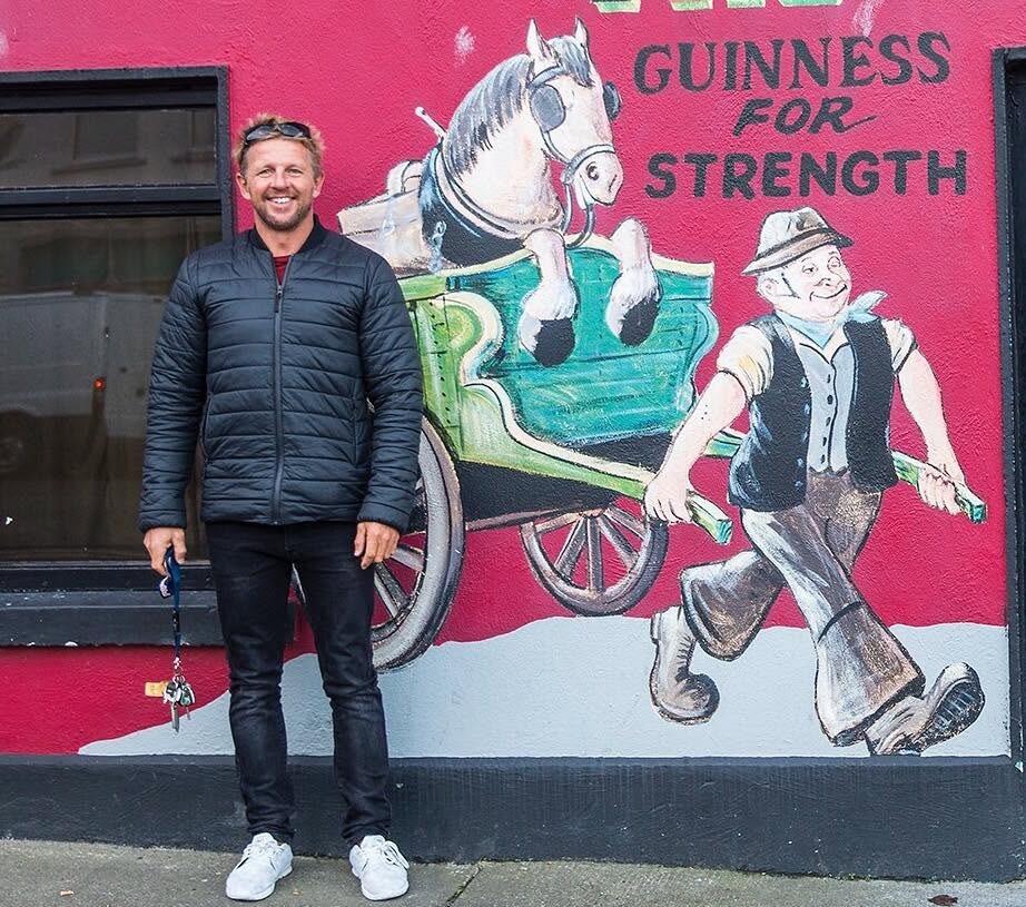 Timo Mullen beside a Guinness mural, Ireland
