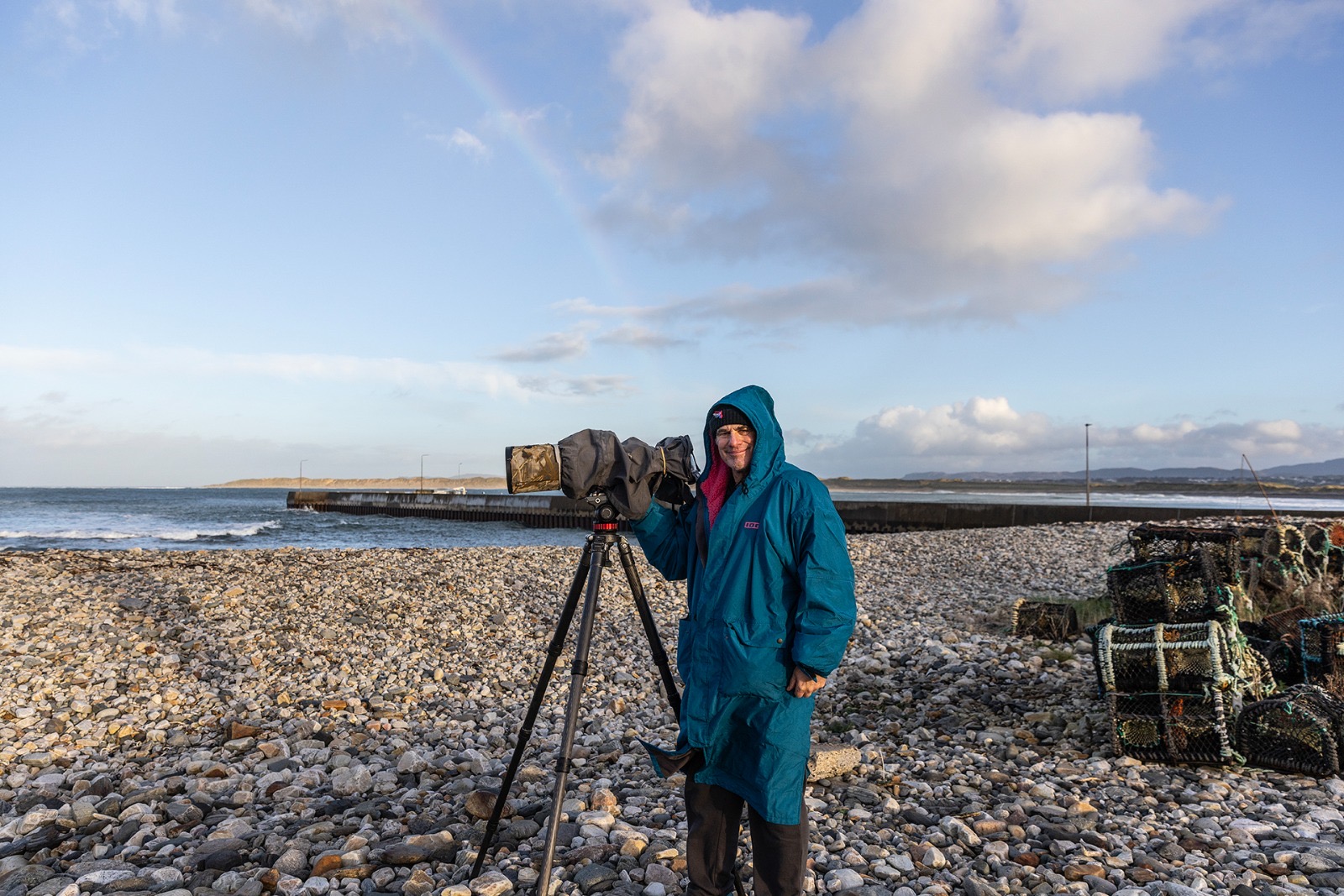 Timo checking conditions with a spotting scope on a rocky beach